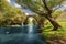 Ancient stone bridge over the blue river in the forest. Fairy tale background