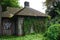 Ancient stone cottage with painted graffiti and overgrown with vines