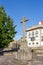 Ancient stone cross in medieval square. Old building and cross in cathedral yard. Religion and faith concept.