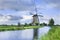 Ancient stone low sail mill near a canal with dramatic clouds, The Netherlands