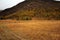 Ancient stone menhirs at the foot of a high mountain in an autumn valley