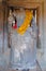 An ancient stone sculpture of a Buddha in a Cambodian temple decorated with yellow robes, a decapitated Buddha