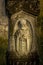 Ancient stone statue on Gothic graves at cemetery in Brody, Ukraine. An old abandoned overgrown cemetery. Traditional Catholic bur