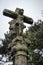 Ancient stone statue with ruined jesus christ figure. Medieval religious sculpture. Old cross with moss and jesus figure.