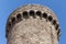 Ancient stone tower in the fortress against the blue sky.