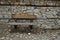 Ancient stone wall texture background with wooden consolidation with bench, town Koprivshtitsa