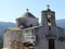 Ancient stones top white church inland Naxos in Greece.