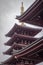 Ancient and traditional Japanese building with red and golden facade in a cloudy day