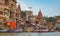 Ancient Varanasi city with old architectural buildings and ancient temples along the Ganges river ghat as viewed from a boat.