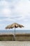 Ancient vintage umbrella or parasol in a beach with Atlantic ocean and cloudy sky, Madeira Island, Portugal