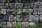 Ancient wall of gray stones entwined with green ivy