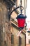 Ancient wall with an old street lamp with red cloth and ribbons with national Polish colors in Lublin, Poland