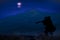 Ancient warrior stranger vagabond person silhouette in fur cape with ax stay back to camera on a hill at phantom blue night nature