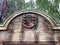 Ancient, weathered stone arch with engraved coat of arms at Nymans House, West Sussex