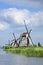 Ancient wind mills near a blue canal on a summer day, Netherlands