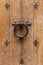 Ancient wooden entrance door with handle and fleur-de-lis ironwork. Saint-Denis, France