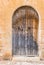 Ancient wooden front door with stone arch of old rustic house