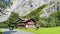 Ancient wooden house in the mountains overgrown with forest of Bernese Oberland