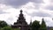 An ancient wooden temple stands in dense greenery.