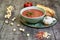 Andalusian gazpacho bowl with parsley and extra virgin olive oil, on focus, accompanied by bread and garlic. Around there are