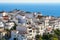 Andalusian white village on a hill and overlooking the blue sea in the background. Frigiliana Malaga.