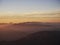 Andean sunset panorama colorful mountain layers haze fog seen through airplane window seat near Santiago de Chile