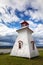Anderson Hollow lighthouse by the Shepody River dam in Harvey, Bay of Fundy, New Brunswick. Summer day with rolling clouds
