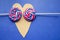 Andy swirl rainbow round two lollipops on heart-shaped. Candy stripes on a stick on blue background. Love concept. February 14. Ho