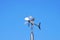 Anemometer wind speed indicator measuring device under blue sky and clouds