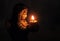Angel holds a burning candle in the dark. background religion, p