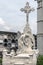 Angel sculpture and crucifix on grave in Poblenou Cemetery in Barcelona, Spain