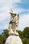 Angel Statue on a mound beside a Religious Cross