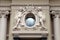 Angel statues and oval window at baroque style facade