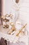 Angel statuette with golden Christmas ornaments and leaves in bowl and small white Santa sitting on dressing table.