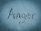 Anger, word written on blue sand