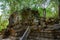 Angkor, Siem Reap, demaged Temple of Beng Mealea, Cambodia. Big roots over walls and roof of a temple.