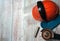 Angle grinder, piece of metal pipe, gloves, orange helmet with safety glass on wooden background.