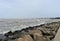 Angle view of the granite rock dam on the shoreline and the ocean tides