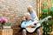 Angle view of retired husband playing acoustic guitar near happy wife