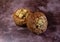 Angle view of two cinnamon crumb muffins on a bright maroon tabletop