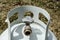 Angled overhead close-up of the top of a white propane tank