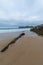 Angled perspective of beach with rocks, with cloudy and blue sky, in Comillas, Cantabria,