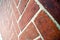 Angled perspective view of diagonal herringbone red brick wall background