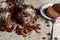 Angled side view of a gourmet round chocolate cake with coconut shreds on icing