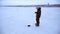 Angler animates bait with his fishing rod and catches fish in winter