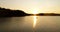 Angler catching fishes on boat at lake at sunset