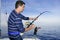 Angler fisherman fighting big fish rod and reel