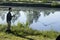 Angler with a fishing rod to catch the ground pulls the groundbait basket