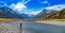 An Angler fly fishing for trout on the Ahuriri river, surrounded by mountains