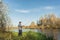 Angler in a jacket with a fishing rod stands on the river bank